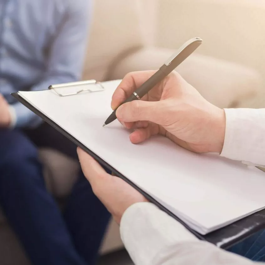 The Psychology Company therapist writing on a clipboard