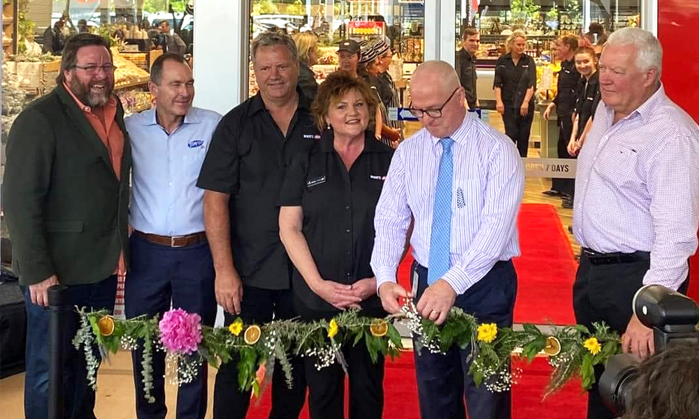 Mayor Mark Jamieson cutting the flower garland to officially open the White's IGA.