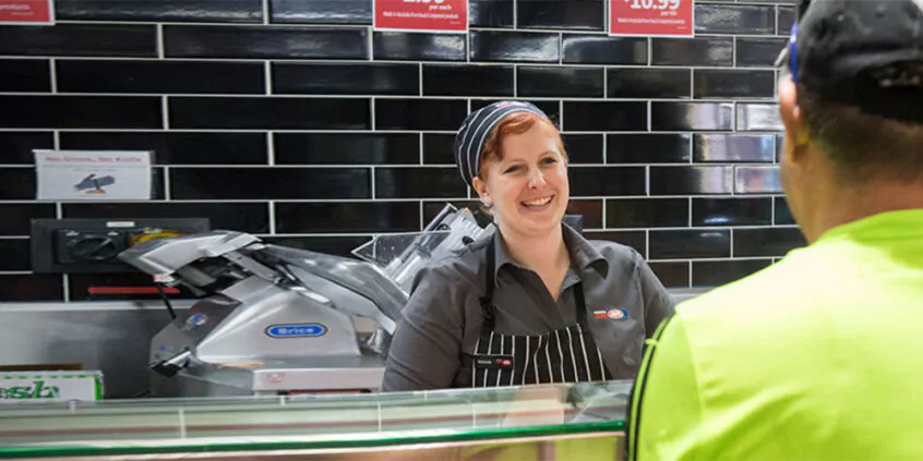 IGA smiling staff member serving a male customer