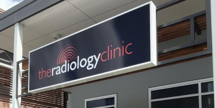 Picture of The Radiology Clinic sign hanging from the Forest Glen Village Centre roof outside the clinic